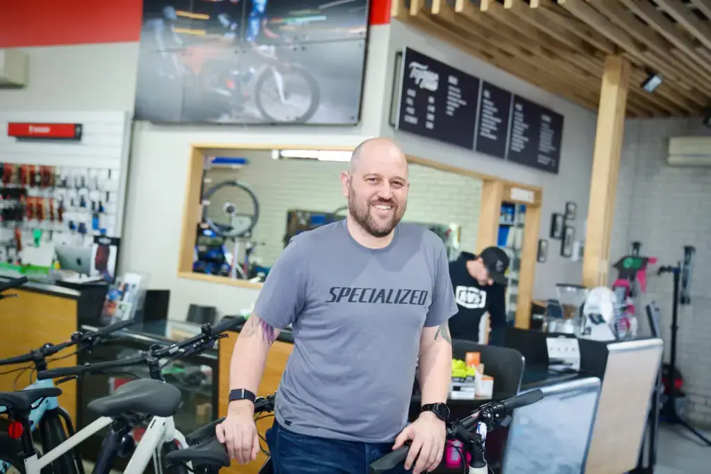 Business owner in bicycle shop posing with bikes in Melbourne by Exposja Photography